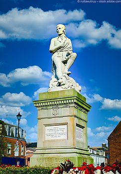 Robbie Burns-Statue vor blauem Himmel in Dumfries, Schottland. 