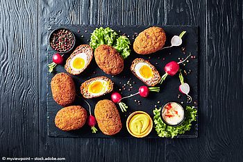 Scotch Eggs angerichtet auf einer schwarzen Platte