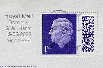 Pflaumenviolette 1.-Klasse-Briefmarke der britischen Royal Mail mit dem Antlitz von König Charles III. auf einem Briefumschlag