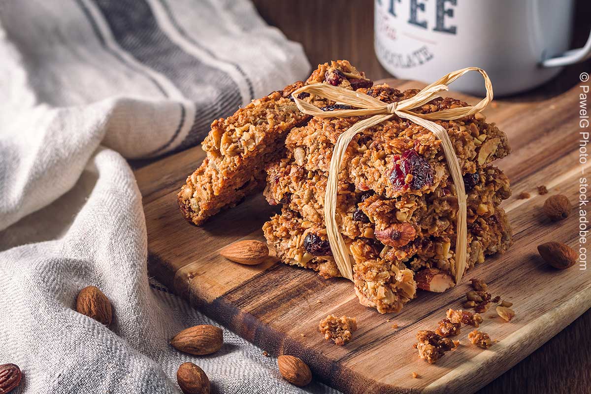 Selbstgemachte Flapjacks mit Mandeln und Cranberrys auf einem Holzbrett