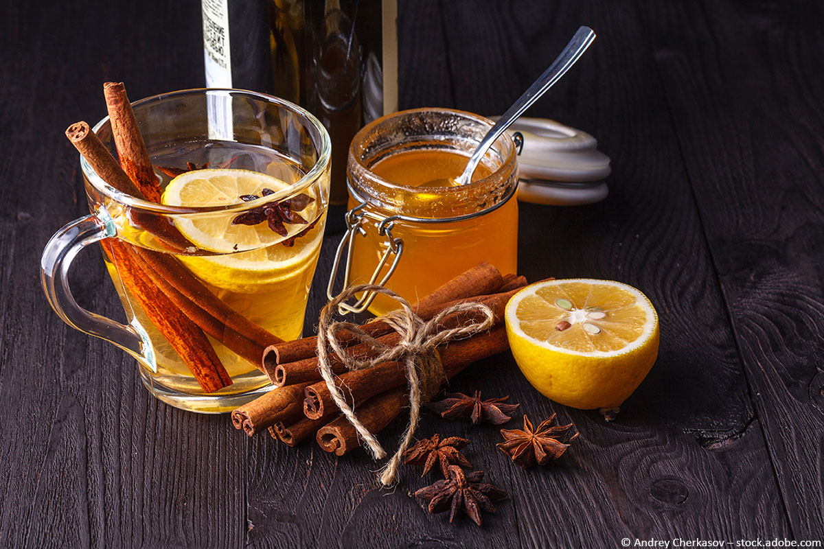 Ein Hot Toddy im Glas mit Zimtstange und Zitrone