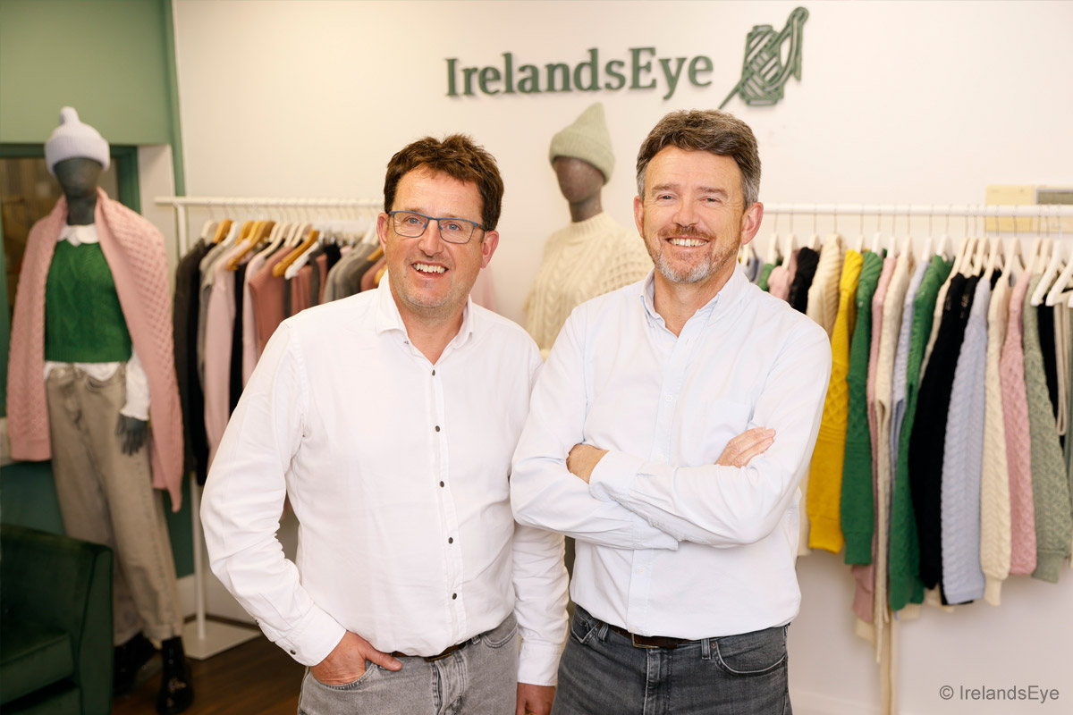 Brendan O'Sullivan (Direktor; links im Bild) und Paul O'Sullivan (Geschäftsführer; rechts im Bild.) stehen vor Kleiderständern mit Produkten ihres Unternehmens IrelandsEye Knitwear.